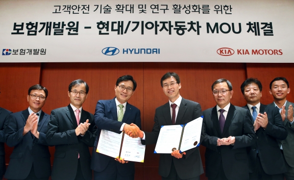 현대∙기아차와 보험개발원은 24일(목) 현대차 양재동 본사 사옥에서 업무 협약을 맺고, 자동차 능동안전기술 탑재 차량에 대한 적정 보험료 책정 연구를 위해 상호 협력하기로 했다. 사진은 현대자동차 고객안전전략사업부 김헌수 부사장(사진 가운데 우측)과 보험개발원 권흥구 부원장(사진 가운데 좌측)이 업무 협약서에 사인한 뒤 악수를 나누고 있는 모습. 제공ㅣ현대기아차.