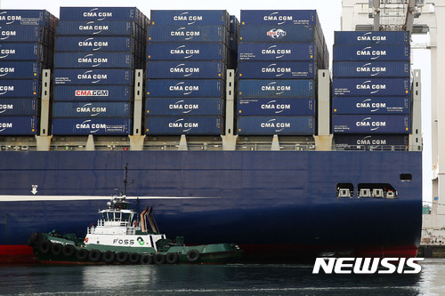 미 시애틀 항구의 터미널 18에서 포스 사의 조그만 예인선 한 척이 CMA CGM의 대형 컨테이너선 벤자민 프랭클린 호를 부두 쪽으로 밀고 있다. [사진=뉴시스/AP]