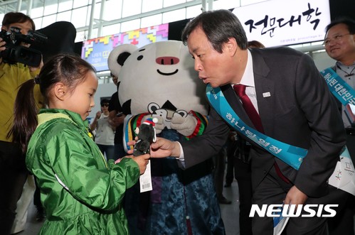 도종환 문화체육관광부장관이 추석 연휴를 앞둔 지난 9월 서울역에서 열린 2018평창동계올림픽대회 홍보행사에 참석해 한 어린이에게 2018평창동계페럴림픽대회 마스코트인 반다비 인형을 나눠주고 있다. [사진=문화체육관광부]