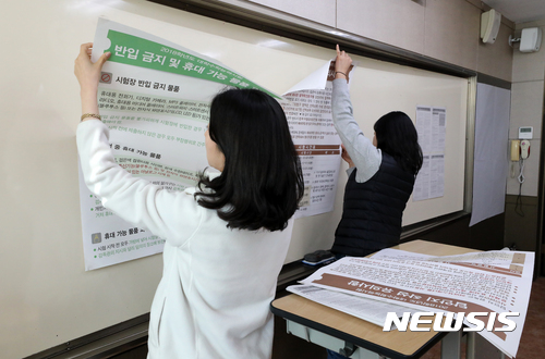 포항 지진 여파로 대학수학능력시험이 1주일 뒤로 연기된 16일 오전 서울 중구 이화여자외국어고등학교 제 19시험장 교실에 부착된 안내문이 철거되고 있다.[사진=뉴시스]