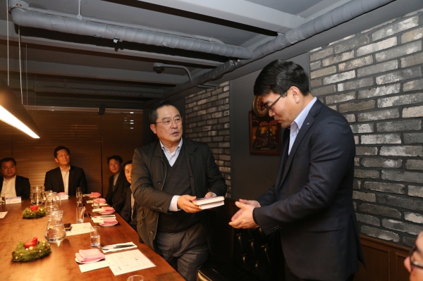 구자열 LS그룹 회장(왼쪽)이 26일 LS전선 부스덕트 사업부 김우태 이사에게 책 '불타는 투혼'을 선물하고 있다. 사진=LS그룹 제공