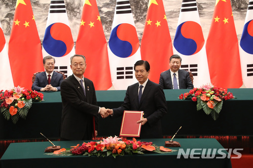 【베이징(중국)=뉴시스】전진환 기자 = 문재인 대통령이 시진핑 중국 국가주석과 14일 오후(현지시각) 중국 베이징 인민대회당에서 백운규 산업통상자원부장관과 중국 중산 상무부장 한-중 FTA 서비스 투자 후속협상 양해각서 서명식을 지켜보고 있다. 2017.12.14. amin2@newsis.com [출처=뉴시스]
