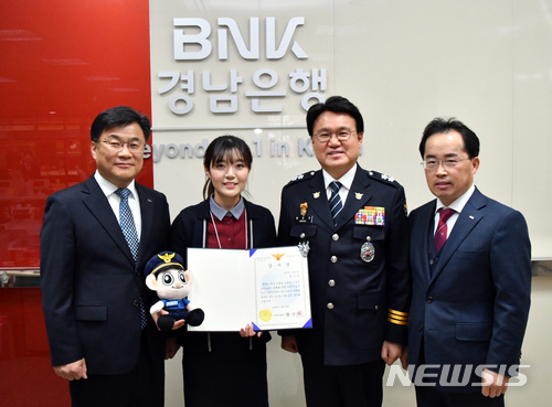 18일 황운하 울산지방경찰청장(오른쪽 두번째)이 BNK경남은행 야음동지점을 방문해 지난 10일 1500만원 상당의 보이스피싱 피해 예방에 기여한 은행 직원에게 감사장을 전달한 뒤 기념촬영을 하고 있다.ㅣ사진=뉴시스