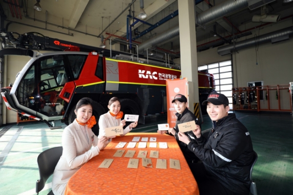 2월6일 기내에서 캐리커처와 페이스페인팅 특화서비스를 제공하는 제주항공 ‘JJ일러스타팀’ 객실승무원들이 설을 앞두고 김포국제공항 소방구조대를 찾아 대원들에게 멋글씨(캘리그래피)로 꾸민 세뱃돈봉투를 직접 만들어주고 있다. 제공=제주항공.
