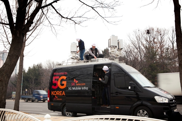 SK텔레콤 Network기술원 연구원들이 분당구청 잔디광장에 「이동형 5G 인프라」를 설치하고, 가상화 플랫폼으로 소프트웨어를 변경하며 5G 성능을 최적화하고 있다.