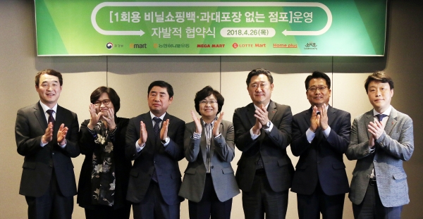 환경부와 대형마트 5개사(이마트, 홈플러스, 롯데마트, 하나로마트, 메가마트)가 26일 오후 서울 더플라자호텔에서 '1회용 비닐쇼핑백, 과대포장 없는 점포 운영 자발적 협약식'을 가진 가운데 참석자들이 협약을 마친 후 기념촬영을 하고 있다. (왼쪽부터)강성태 메가마트 MD본부장, 문미란 소비자시민모임 부회장, 김성광 농협하나로유통 대표이사, 김은경 환경부 장관, 이주희 이마트 경영지원본부장, 전화수 홈플러스 운영부문장, 남창희 롯데마트 MD본부장. [사진=이마트]