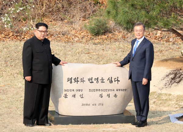 문재인 대통령이 김정은 북한 국무위원장과 27일 오후 판문점 군사분계선에서 소나무 식수 표지석 제막 후 박수치고 있다. [사진=한국 공동 사진기자단]