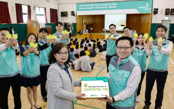 곽용선 기아차 경영전략실장(오른쪽)과 강경옥 반원초등학교 교감선생님(왼쪽)이 ‘그린 라이트 카드’ 전달을 기념해 포즈를 취하고 있는 모습ㅣ사진=현대기아차