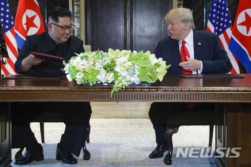 도널드 트럼프 미국 대통령과 김정은 북한 국무위원장이 12일 싱가포르 센토사 섬 내 카펠라 호텔에서 합의문에 서명한 후 웃고 있다. 2018.08.12 [싱가포르=AP/뉴시스]