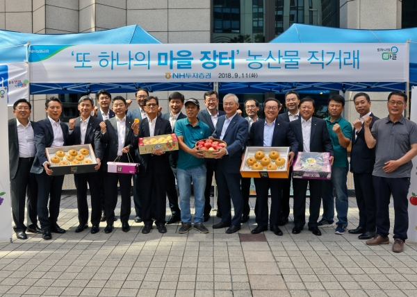 NH투자증권이 11일 여의도 본사에서 자매결연을 맺은 농가와 직거래 장터를 개장한 가운데 정영채 사장(앞줄 왼쪽에서 일곱번째)과 농민, 임직원이 기념 촬영을 하고 있다.[사진=NH투자증권]