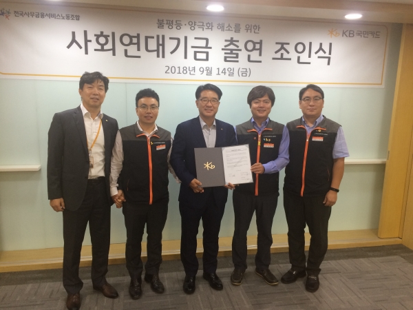 이동철 KB국민카드 대표(왼쪽에서 두 번째)가 사무금융노조 관계자들과 14일 오후 3시 KB국민카드 본사 대회의실에서 불평등 양극화 해소를 위한 사회연대기금 출연 조인식을 개최한 후 기념촬영을 하고 있다. [사진=전국사무금융노조]