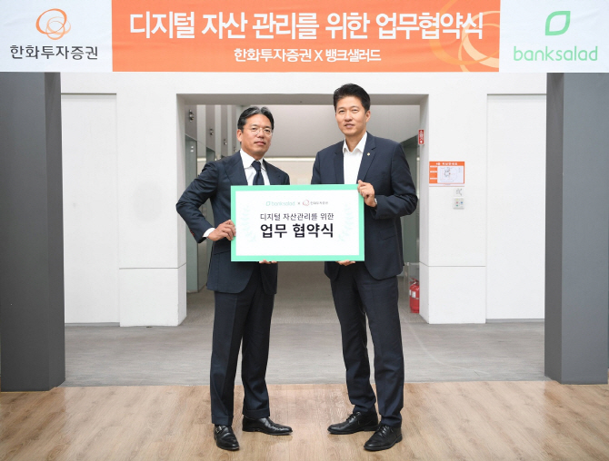 김동욱 한화투자증권 디지털전략실 상무(오른쪽) 와 최재웅 레이니스트 CRO가 지난 14일 서울 여의도 한화투자증권 본사에서 MOU 체결 후 기념촬영을 하고 있다. [사진=한화투자증권]