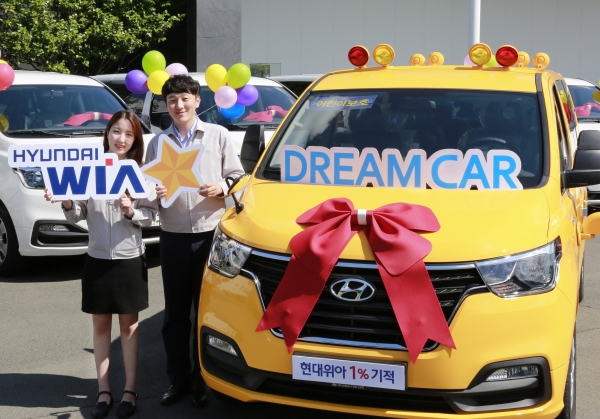 현대위아 임직원들이 1일 경남 창원시 성산구 현대위아 본사에서 열린 ‘2018년 DREAM CAR 전달식’에서 복지기관에 전달할 어린이 보호차량과 함께 기념사진을 찍고 있다 [사진=현대위아]
