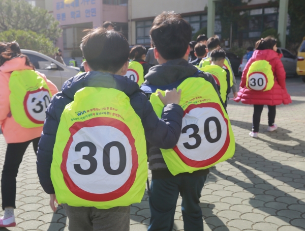 20일 경남 창원시 성산구 안민초등학교에서 학생들이 현대위아가 기증한 어린이용 안전 가방 덮개를 씌운 가방을 메고 하교하고 있다. 현대위아는 내년 1학기 개학 전까지 전국 사업장 인근 초등학교에 2만여개의 안전 가방 덮개를 배포할 계획이다. [사진=현대위아]
