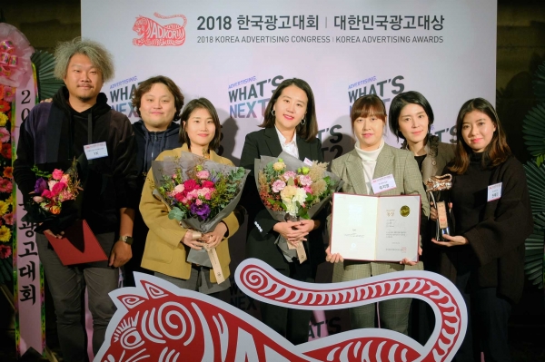 박현경 IMC전략총괄팀장(사진 가운데)이 수상 후 직원들과 함께 기념촬영을 하고 있다. [사진=하나투어]