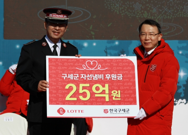 30일 광화문 광장에서 열린 2018 구세군 자선냄비 시종식에서 오성엽 롯데지주 커뮤케이션실장(오른쪽)이 김필수 한국구세군 사령관(왼쪽)에게 후원금 25억원을 전달하고 있다.