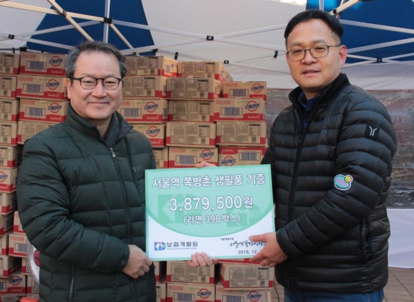 보험개발원 성대규 원장(왼쪽에서 세번째)과 유지호 상무(왼쪽에서 두번째) 등 보험개발원 임직원들이 12일 서울 동자동에서 쪽방촌에 전달할 생필품을 들고 사진을 찍고 있다. [사진=보험개발원]