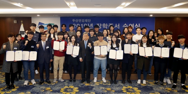 '2019년 두산연강재단 장학증서 수여식'에서 박용현 두산연강재단 이사장(앞줄 왼쪽에서 여섯번째)이 학생들에게 장학증서를 전달한 뒤 기념촬영을 하고 있다. [사진=두산]