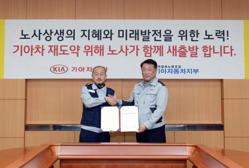 18일 오전 경기 광명시 기아자동차 소하리공장 본관 회의실에서 열린 노사 통상임금 특별합의 조인식에서 강상호 노조 지부장(왼쪽)과 최준영 부사장(오른쪽)이 악수하고 있다. [사진=기아자동차]