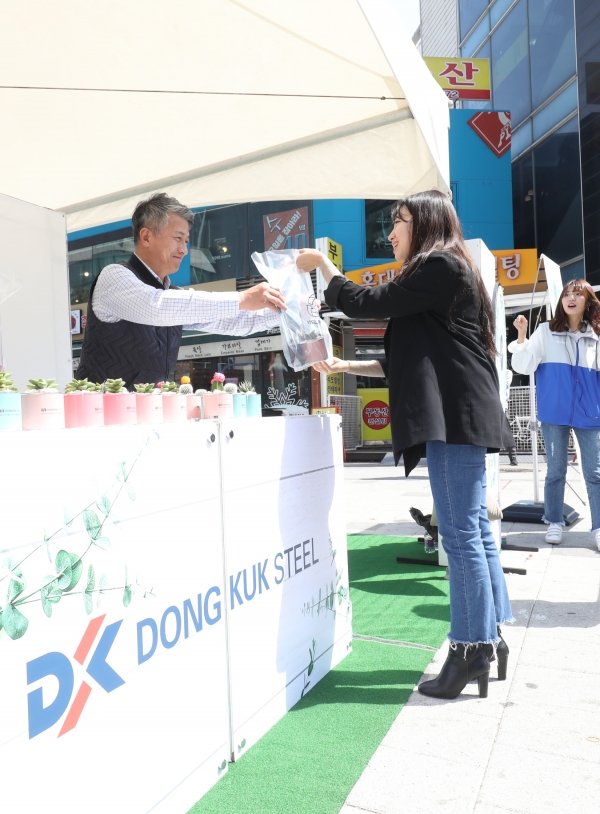 장세욱 동국제강 부회장이 철의 친환경성을 홍보하기 위한 ‘그린 캠페인’ 일환으로 임직원들과 15일 서울 마포에서 한 시민에게 철로 만든 미니 화분을 나눠주고 있다. [사진=동국제강]