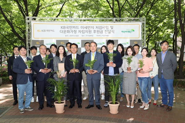 3일 KB국민카드 본사에서 열린 '미세먼지 저감 사업 및 다문화 가정 지원 후원금 전달식'에서 이동철 KB국민카드 사장(앞줄 왼쪽에서 네번째)와 이제훈 초록우산 어린이재단 회장(앞줄 왼쪽에서 다섯번째)이 행사 참석자들과 아동 보육시설에 전달할 실내 공기 정화용 반려나무를 들고 기념 촬영을 하고 있다. [사진=KB국민카드]