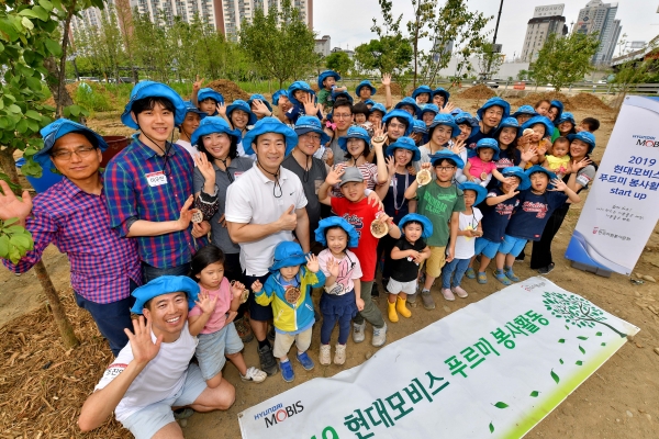현대모비스 직원 가족 봉사단이 한강공원 이촌지구에서 ‘현대모비스 정원’을 조성하기 위해 팽나무와 갈참나무 묘목 100여 주를 심고 있다. 이들은 1년간 나무와 꽃을 심고 계절에 맞는 관리 활동을 한다 [사진=현대모비스]