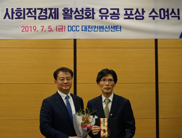 지난 5일 대전컨벤션센터(대전시 수성구 소재)에서 열린 '2019 사회적경제 활성화 유공 포상 수여식'에서 오도영 이지무브 대표(사진 오른쪽)와 방기선 기획재정부 차관보가 기념사진을 찍고 있는 모습 [사진=현대자동차그룹]