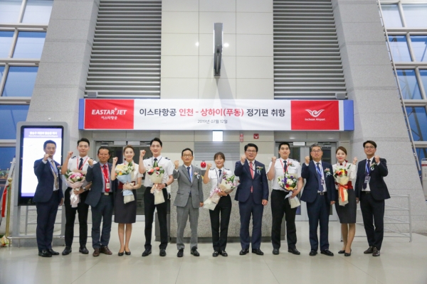 12일 오후 인천국제공항 114번 탑승게이트에서 이스타항공 임직원들과 상하이 첫 편에 탑승하는 승무원들이 함께 신규취항을 기념하며 화이팅을 외치고 있다 [사진=이스타항공]