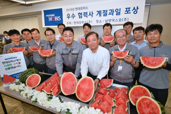 경기도 안산시 남양넥스모㈜ 대표와 직원들이 현대모비스가 전달한 수박을 들어보이며 활짝 웃고 있다. 현대모비스는 이달 말까지 AS순정 부품의 공급에 힘쓴 우수 협력사 250개사와 전국 1,300여 곳 대리점에 감사장과 함께 수박 1만여 통을 전달한다 [사진=현대모비스]