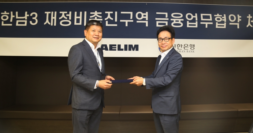 대림산업 이종태 주택영업실장(왼쪽)과 신한은행 이영철 본부장(오른쪽)이 한남3구역 재개발 사업비 조달을 위한 금융업무협약을 체결하고 협약서를 교환하고 있다. [사진제공-대림산업]