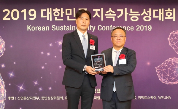 KT 홍보실 지속가능경영담당 정명곤 상무(왼쪽)가 ‘2019 대한민국 지속가능성 시상식’에서 한국표준협회 이상진 회장과 기념촬영을 하고 있다. (사진=KT)