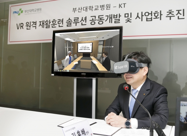 김훈배 KT 커스터머신사업본부장(전무)가 광화문 KT 사옥의 회의실에서 슈퍼VR을 착용하고 가상형 원격 모임 플랫폼을 활용해 부산대병원의 이정주 원장과 환담을 나누는 모습 [사진제공=KT]
