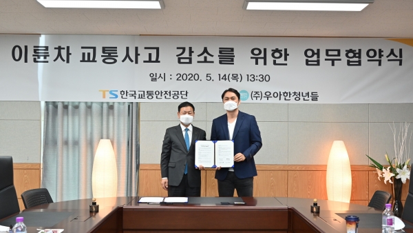 ‘이륜차 교통사고 감소를 위한 업무협약식’에서 우아한청년들 윤현준 대표 (오른쪽), 한국교통안전공단 김종현 교통안전본부장의 기념촬영 [사진제공=우아한청년들]