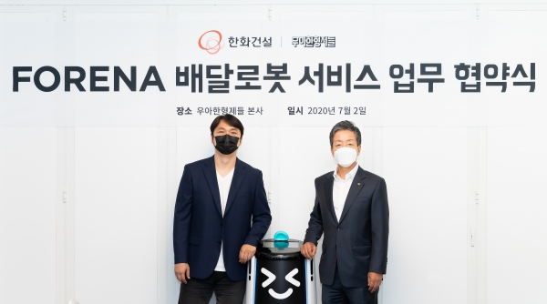 (우측부터) 한화건설 윤용상 건축사업본부장, 배달로봇, 우아한형제들 윤현준 부사장이 ‘FORENA 배달로봇 서비스 업무협약’(MOU) 후 기념촬영을 진행하고 있다. [사진=한화건설]