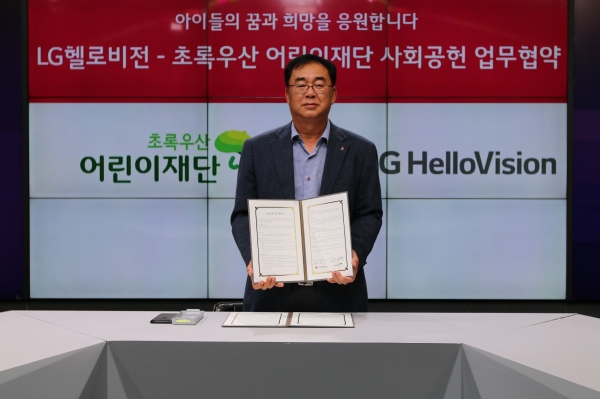 송구영 LG헬로비전 대표가 초록우산 어린이재단과 사회공헌 업무협약서를 보여주고 있는 모습 [사진제공=LG헬로비전]