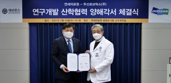 두산로보틱스 최동휘 대표(왼쪽)와 연세의료원 윤동섭 원장이 '의료로봇 연구개발 산학협력' 업무협약식을 마치고 기념사진을 촬영하고 있다.