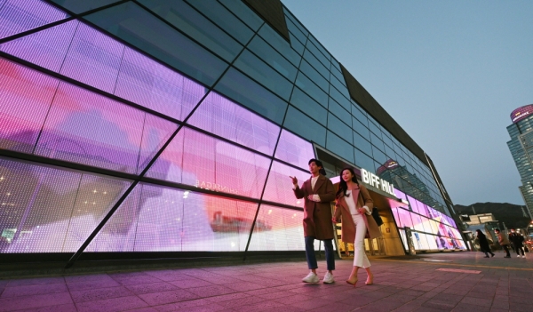 LG전자 모델들이 투명 LED 필름이 설치된 영화의전당 주변 경관을 소개하고 있다. [사진: LG전자 제공]