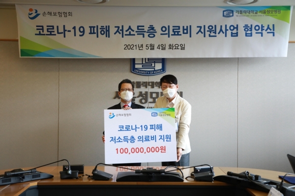 정지원 손해보험협회장(왼쪽)이 김용식 서울성모병원장(오른쪽)에게 의료비 지원금을 전달하고 있다. [사진=손해보험협회]