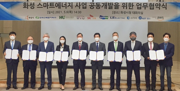 두산퓨얼셀이 6일, 경기도 화성시청에서 화성시, 화성도시공사, 한국수력원자력 등 지자체 및 유관기업과 함께 ‘경기도 화성 스마트에너지 사업 공동개발을 위한 업무협약(MOU)’을 체결했다. 두산퓨얼셀 유수경 대표(왼쪽 두번째)가 협약 체결 후 관계자들과 기념촬영을 하고 있다. (왼쪽부터 LS일렉트릭 박용상 사장, 두산퓨얼셀 유수경 대표, 삼천리 유재권 사장, UVC 이지영 대표, 한수원 정재훈 사장, 화성시 서철모 시장, 화성도시공사 유효열 사장, SK건설 안재현 사장, ADT캡스 박진효 사장, AWS 윤성원 대표)