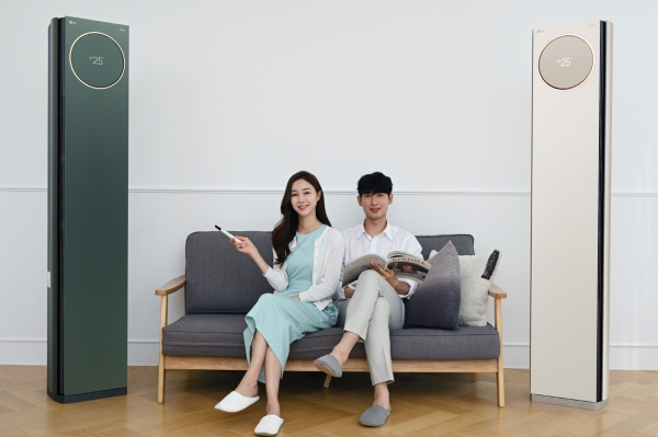 모델들이 오브제컬렉션 색상이 적용된 LG 휘센 타워 에어컨을 소개하고 있다. 왼쪽부터 카밍 그린, 카밍 베이지.[사진: LG전자 제공]