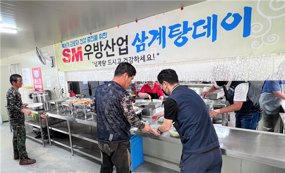 SM우방산업 광주 선교지구 우방아이유쉘 공동주택 신축공사현장에서 근로자에게 혹서기 근로자 건강관리를 위한 삼계탕과 음료를 지급하고 있다. [사진제공=SM우방산업]