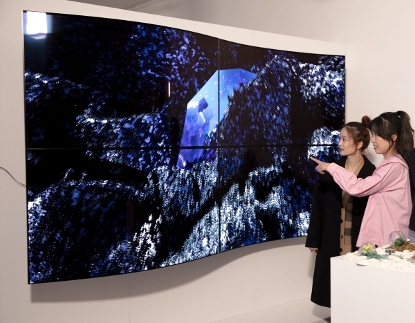 28일(현지시간) 영국 런던에서 열린 디지털아트展 '루미너스(Luminous)에서 관람객들이 LG디스플레이의 55인치 커브드 OLED 패널 4대를 상하좌우로 이어붙여 만든 작품명 ‘보이지 않는 혁신(Invisible Reinvention)’을 감상하고 있다. [사진제공=LG디스플레이]