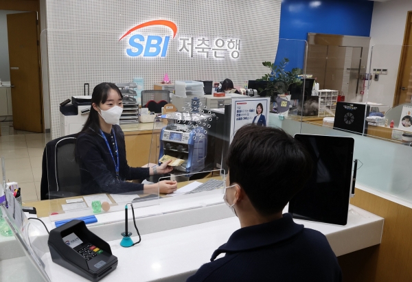 SBI저축은행 청담직원 직원이 소독된 지폐를 고객에게 전달하고 있다. [사진제공=SBI저축은행]