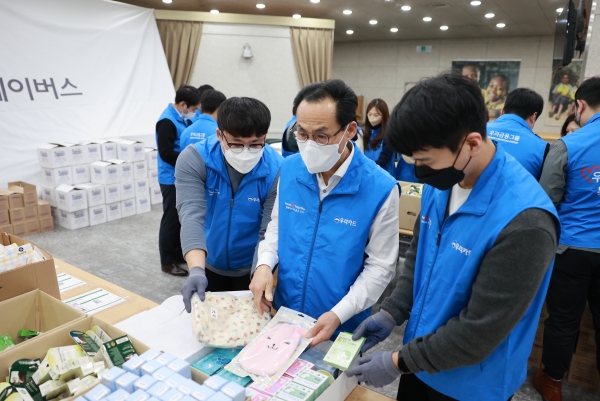이달 26일 영등포구에 위치한 굿네이버스 본부에서 우리카드 김정기 사장(가운데)과 임직원들이 생리대 키트를 직접 포장하고 있다. [사진제공=우리카드]