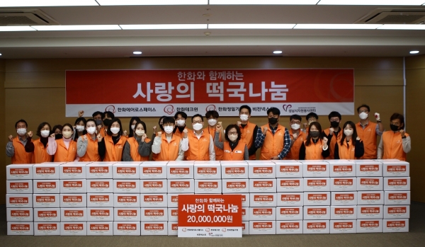18일 한화에어로스페이스 판교 R&D센터에서 열린 ‘사랑의 떡국 나눔’ 행사에 참여한 한화에어로스페이스 손재일 대표이사(중앙), 성남시자원봉사센터 장현자 센터장(중앙 우측)과 한화 임직원 및 봉사센터 관계자들의 모습. [사진=한화에어로스페이스]