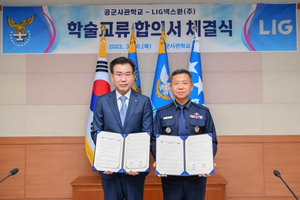 LIG넥스원 이건혁 PGM사업부문장(왼쪽)과 이상학 공군사관학교장(오른쪽)이 학술교류 합의서를 들고 기념 촬영을 하고 있다. [사진=LIG넥스원]
