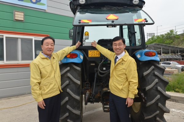 지난 3일 최문섭 대표이사(사진 왼쪽부터)와 농촌진흥청 윤종철 차장이 농기계 사고예방시스템 설치 후 기념촬영을 하고 있다. [사진제공=NH농협손해보험]