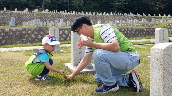 현대엔지니어링 임직원 및 임직원 가족이 국립서울현충원에서 묘역 정화 봉사활동을 하고 있다. [사진제공=현대엔지니어링]