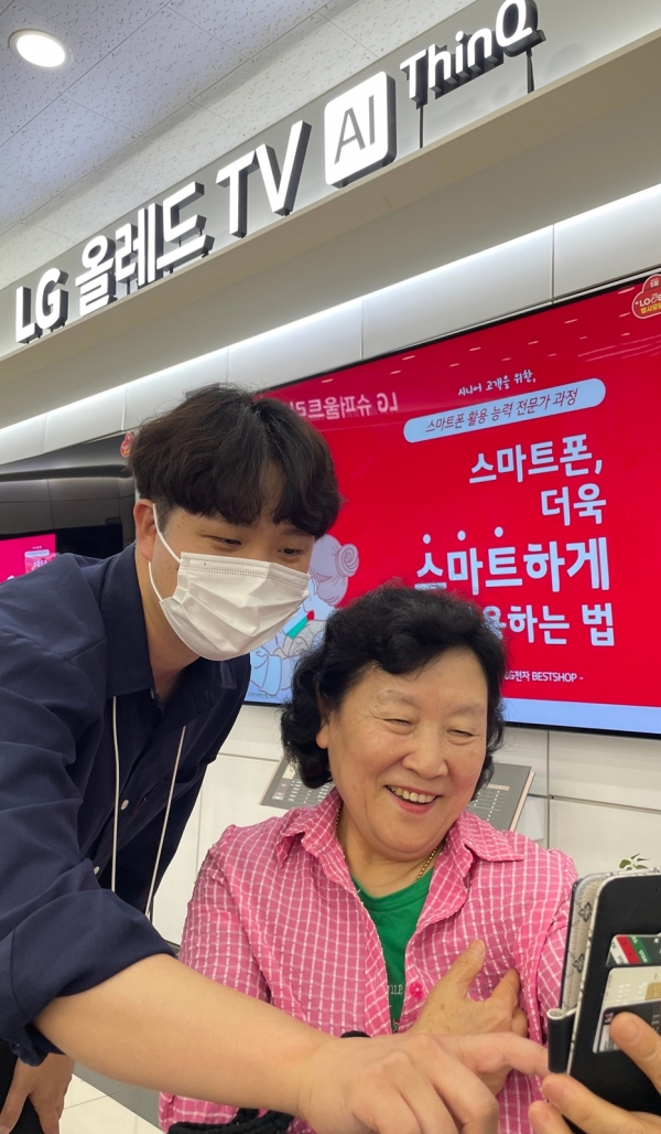 지난 22일 경기도 용인시 수지구 LG베스트샵 수지점에서 지점장과 모바일 매니저가 어르신들에게 스마트폰 활용법을 교육하고 있다. [사진=LG전자]