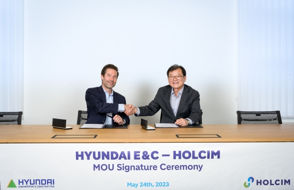 현대건설 기술연구원장 박구용 전무와 홀심 프랭크 부르크하르트 CMO가(오른쪽부터) MOU 체결 후 기념사진을 촬영하고 있다.